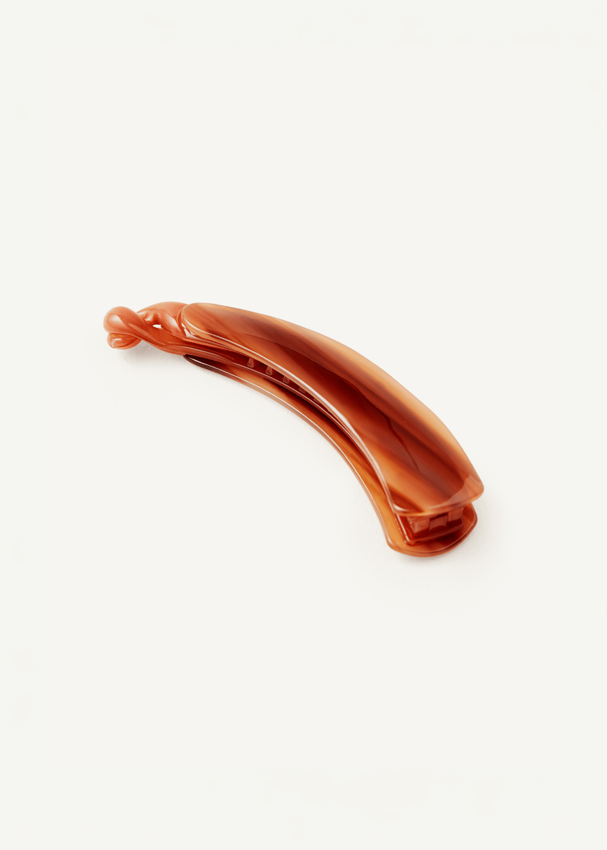 An amber-brown hair claw clip on a clean white background.