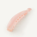 Pink banana hair clip on a white background