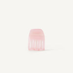A small transparent pink hair clip on a white background