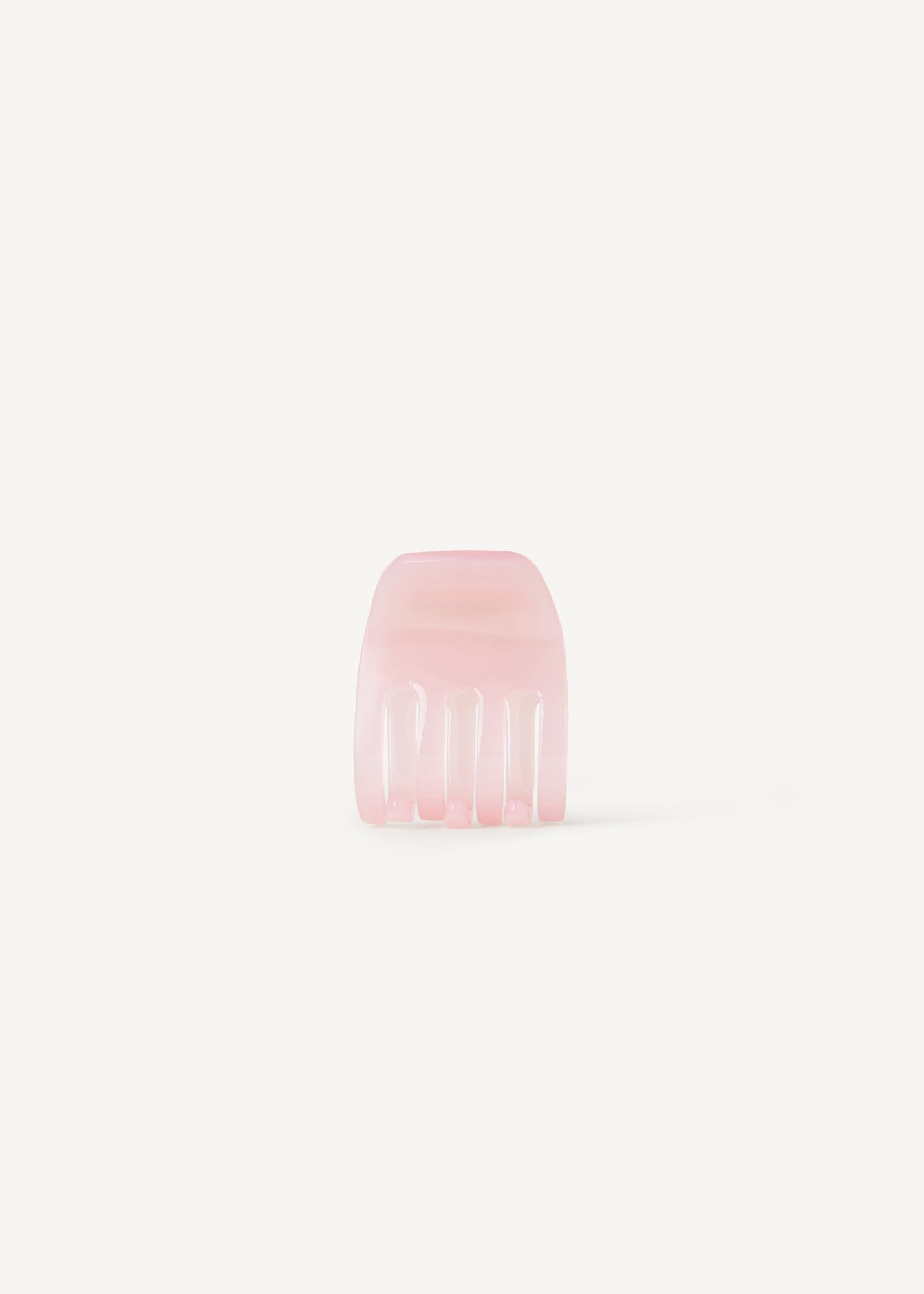 A small transparent pink hair clip on a white background
