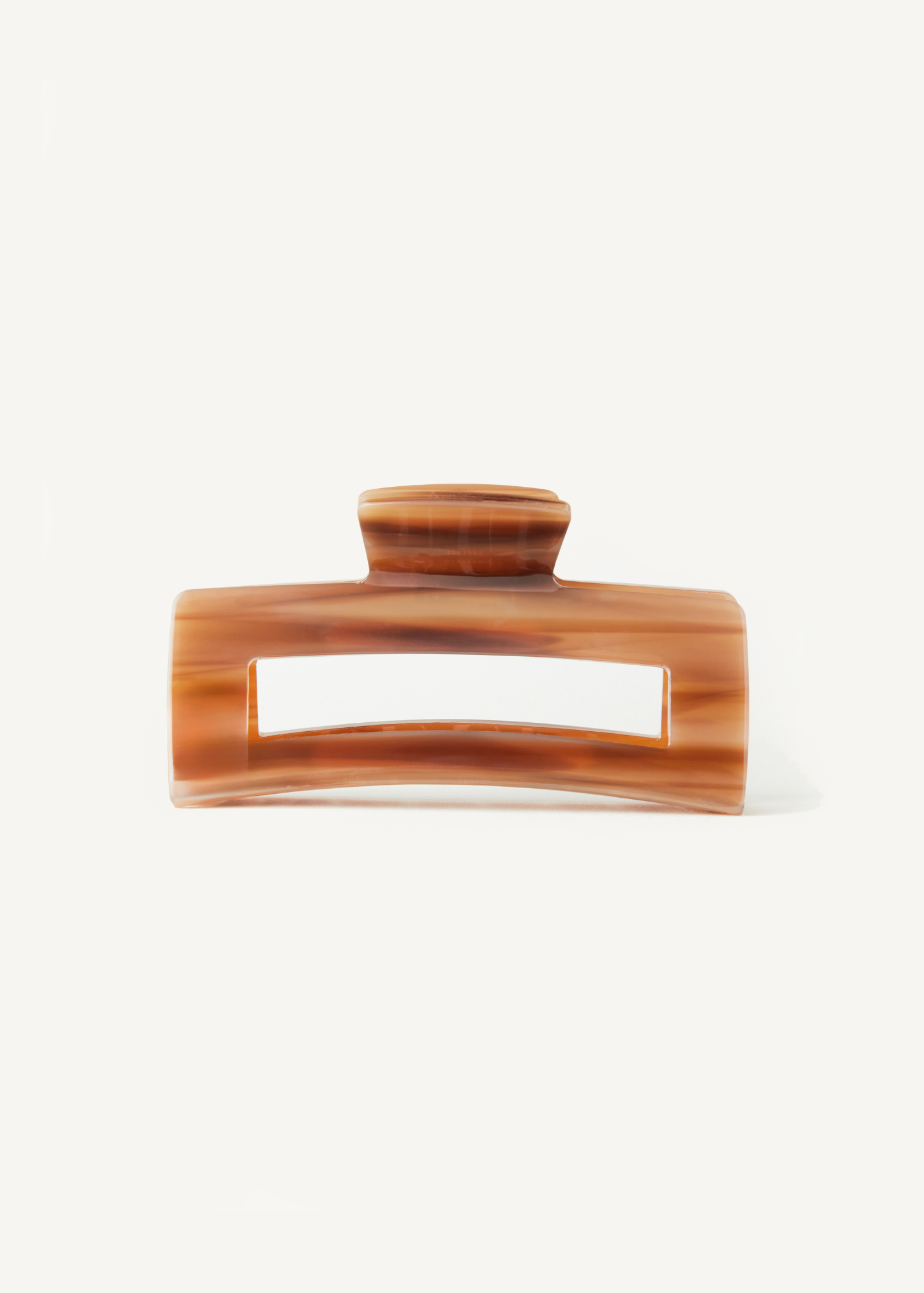 Caramel coloured hair clip on a white background