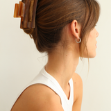 Woman wearing a caramel coloured hair clip against a white background