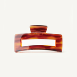 Red-toned neutral hair clip on a white background