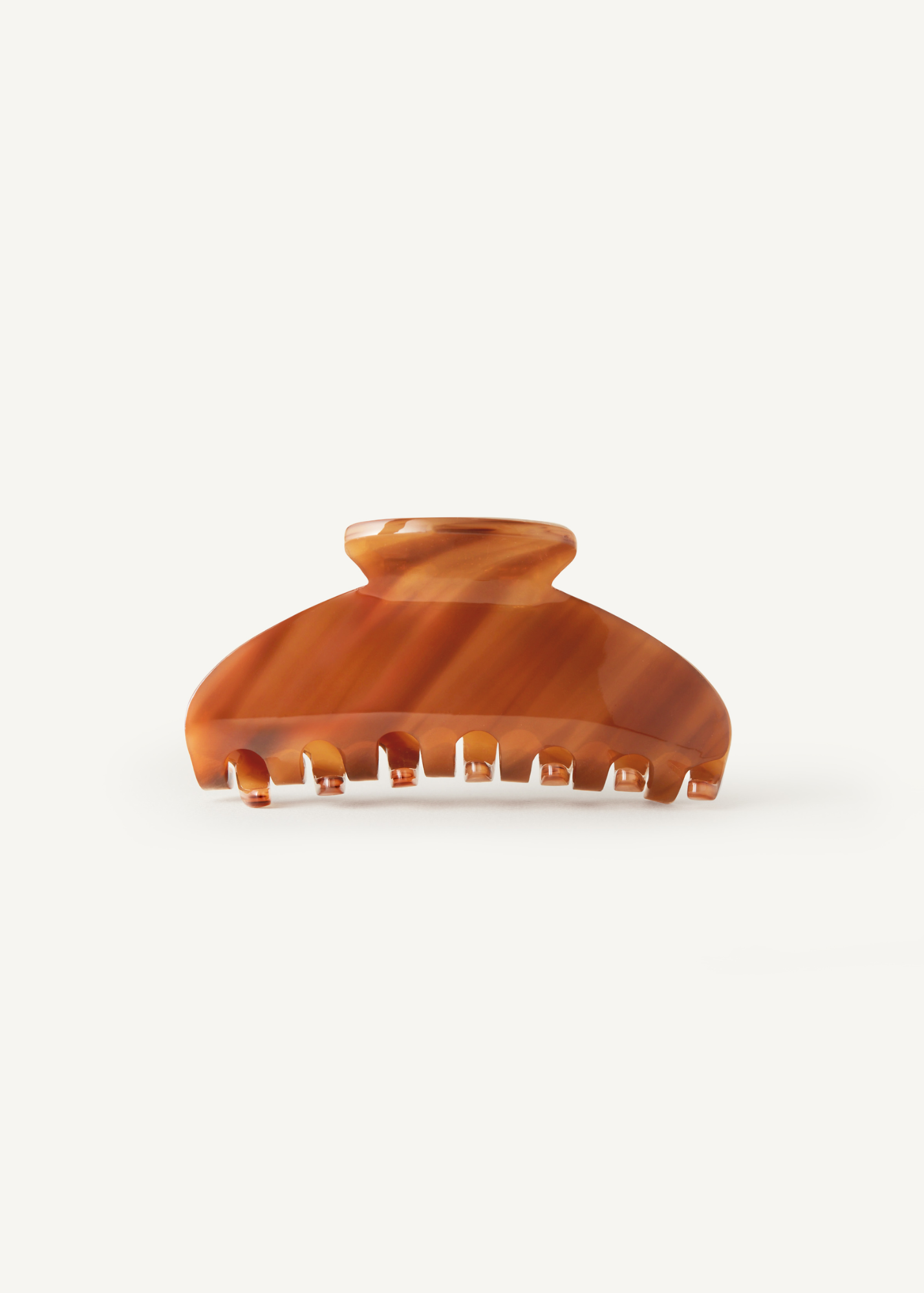 Caramel coloured claw clip on a white background.