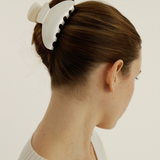 Woman with a medium pearl claw clip against a plain background.