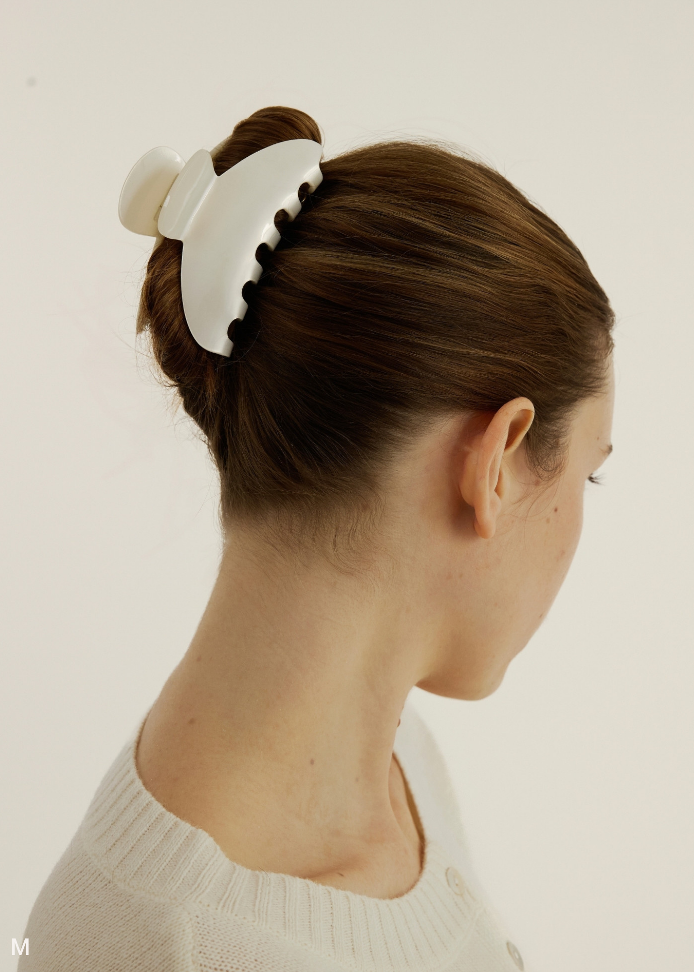 Woman with a medium pearl claw clip against a plain background.