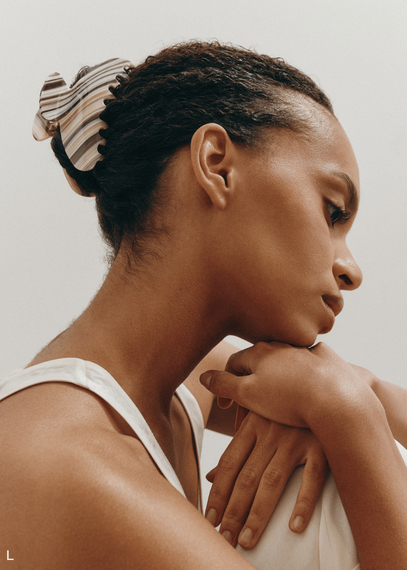 Woman with a striped claw clip looking away from the camera