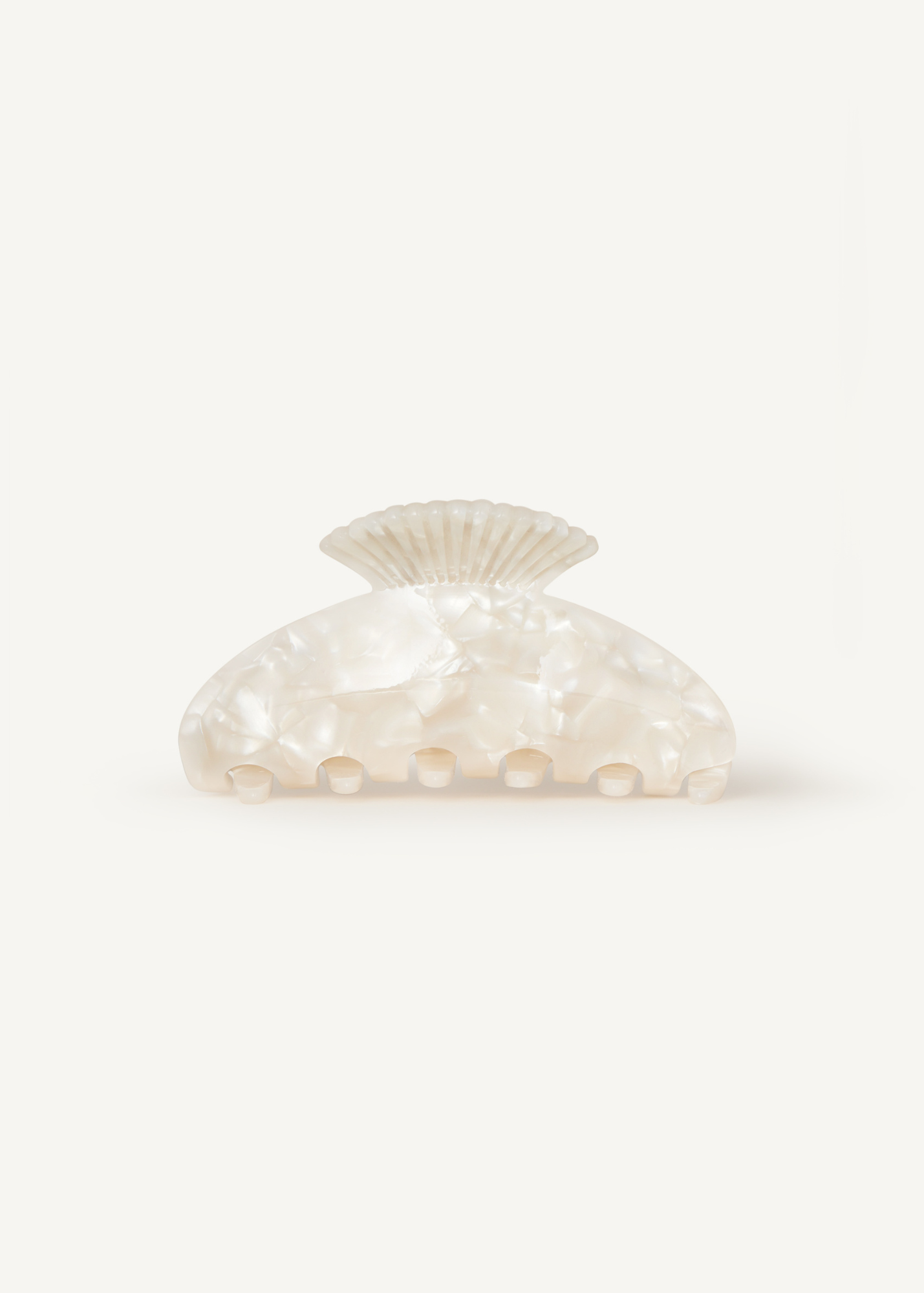 Mother of pearl hair clip with shell detailing on the handle on a white background.
