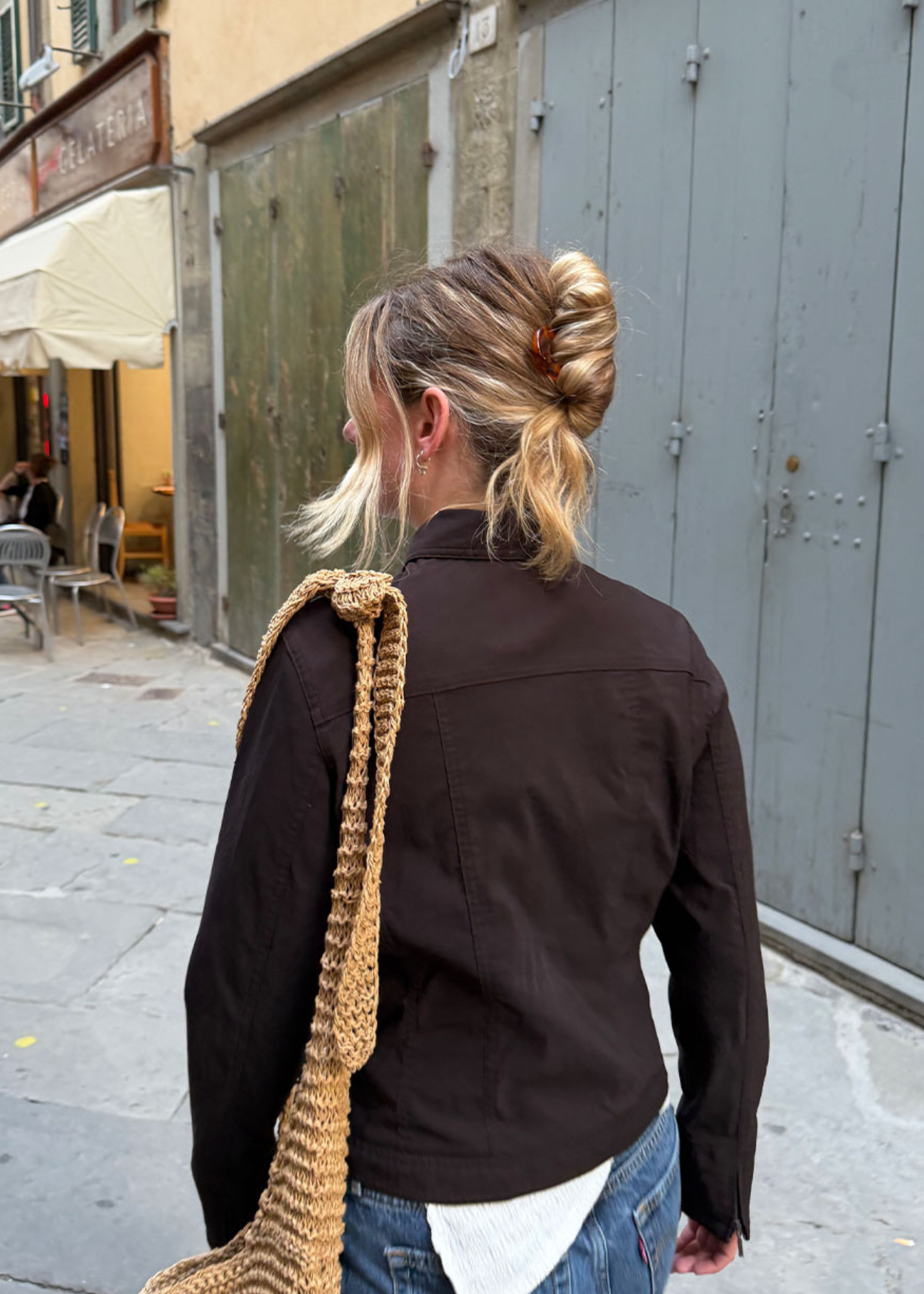 Person walking down the street with their hair in a French Twist secured by a tortoiseshell French Pin.