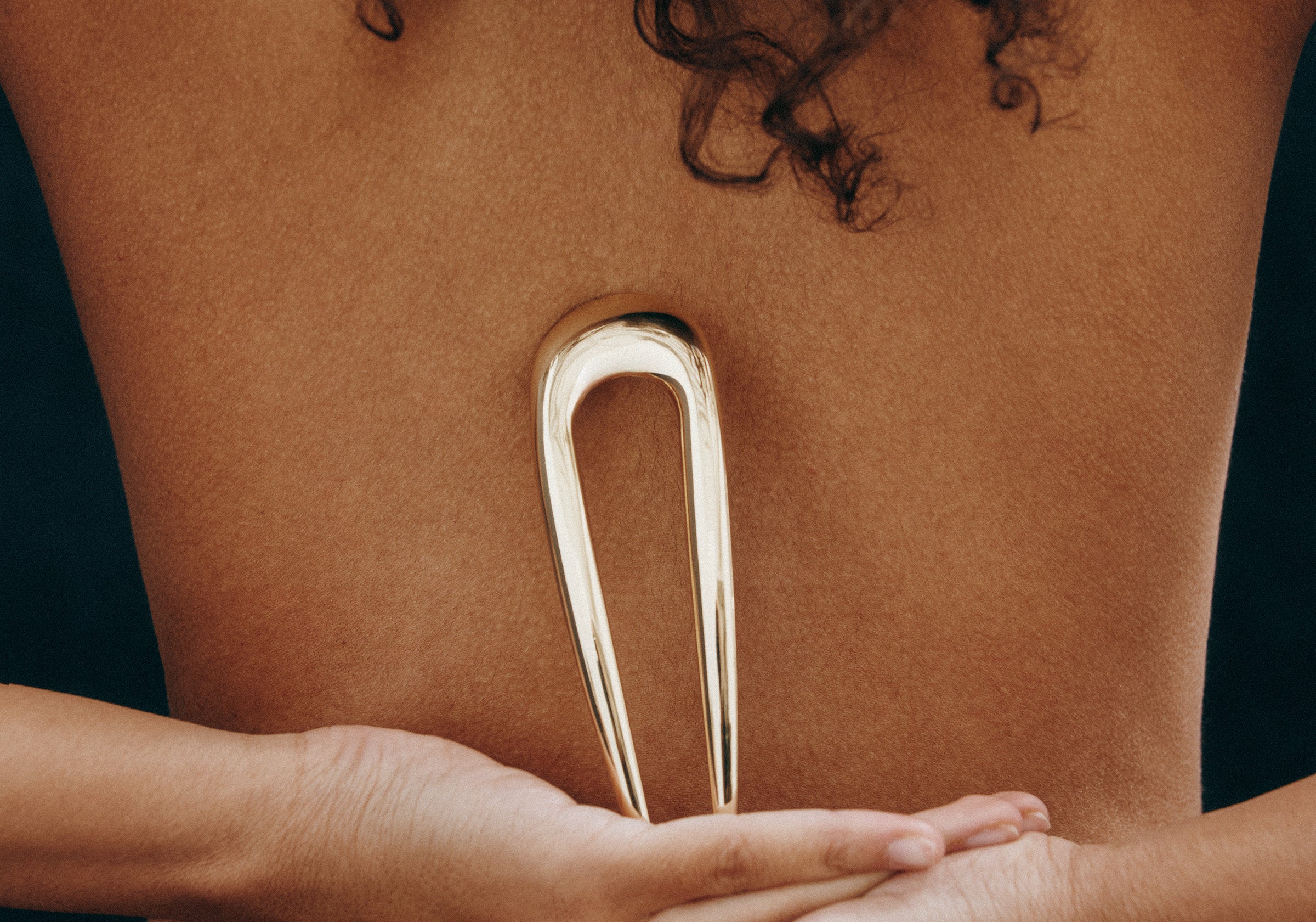 Woman holding the French Pin in Gold against her back