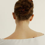 Back view of woman with chestnut coloured hair styled in a bun secured with the French Pin in Tortoise