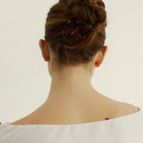Back view of woman with chestnut coloured hair styled in a bun secured with the French Pin in Tortoise