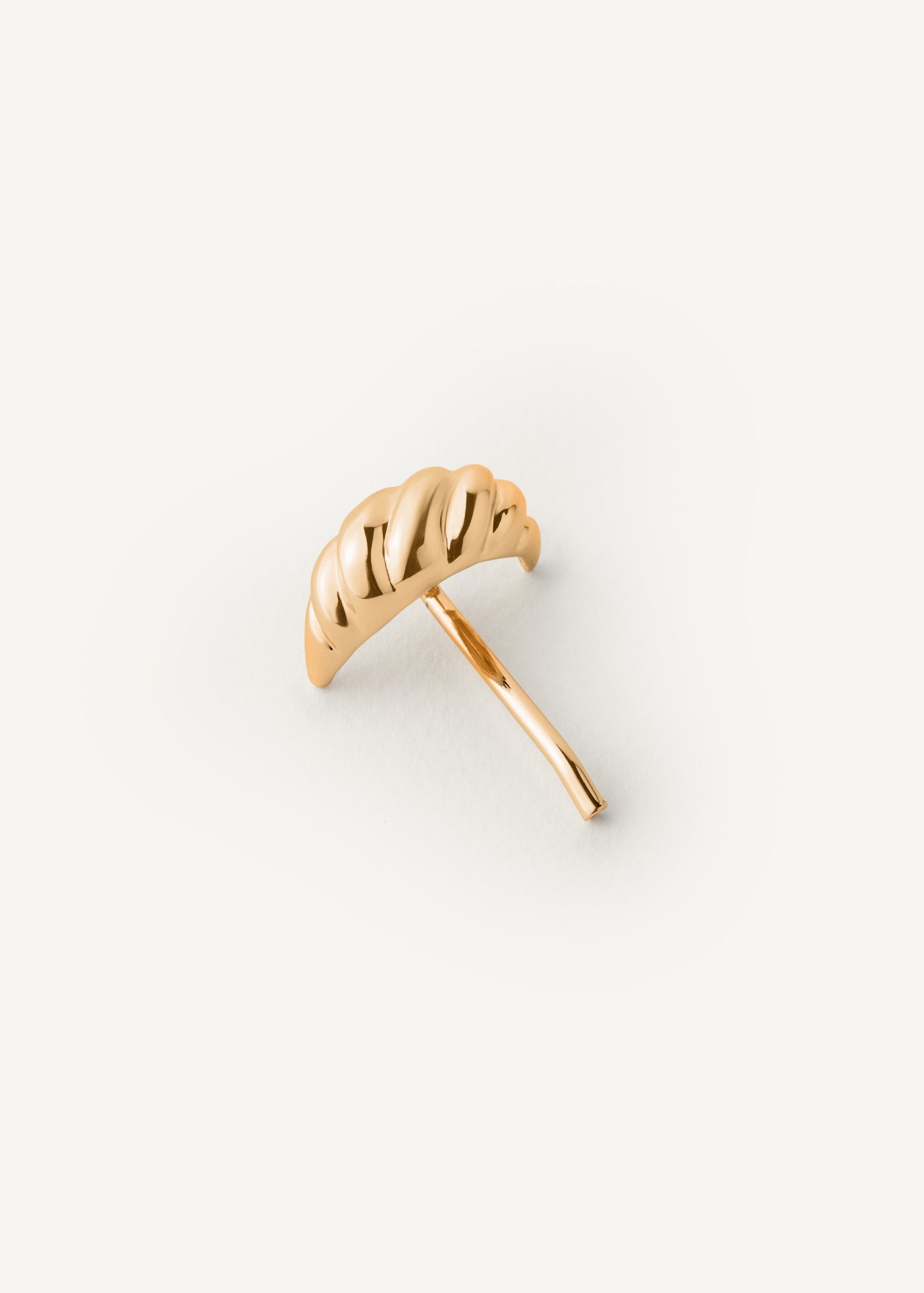 Gold croissant shaped hair accessory on a white background