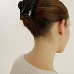 Woman with brown hair styled in an updo secured with a decorative medium-sized claw clip