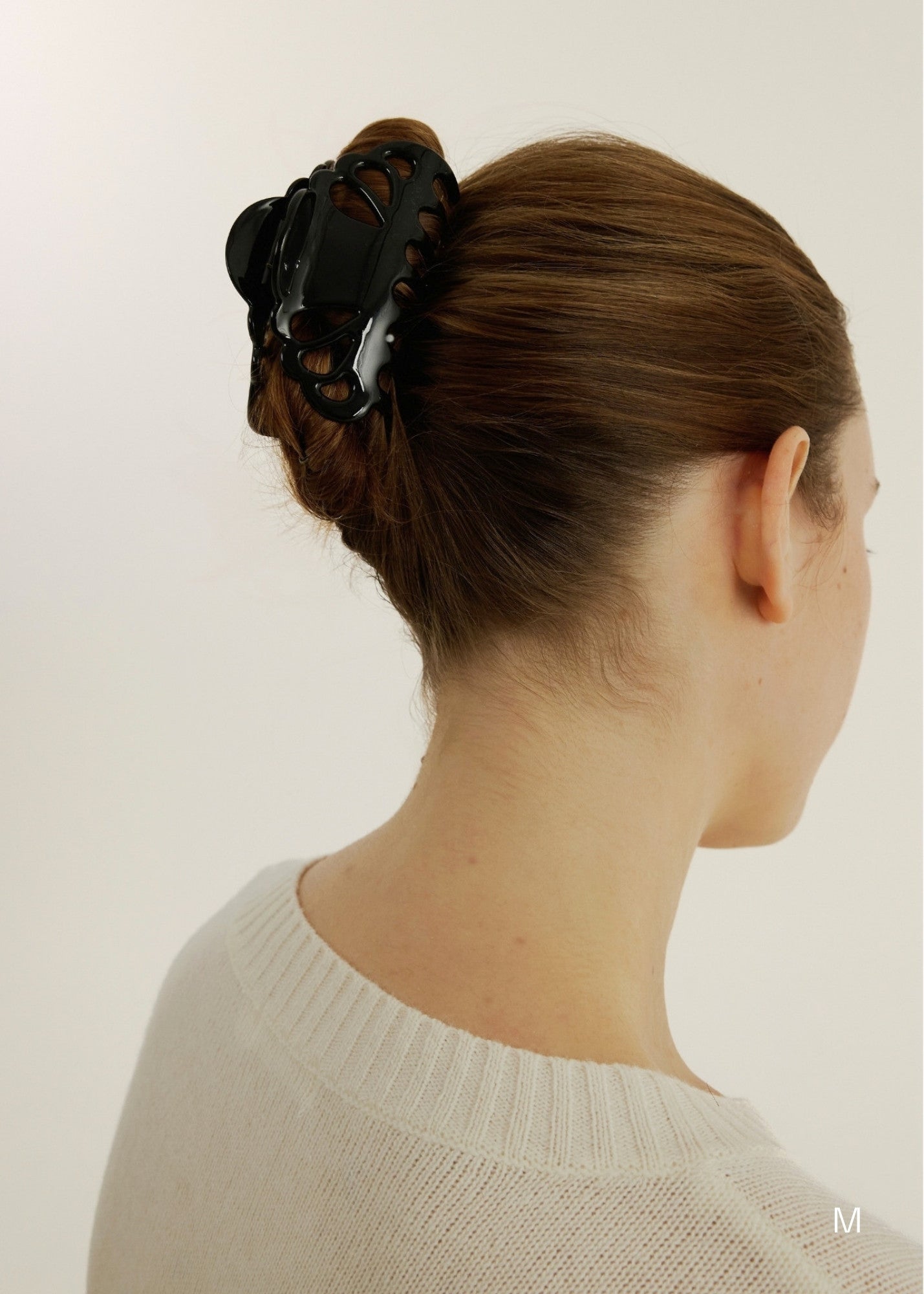 Woman with brown hair styled in an updo secured with a decorative medium-sized claw clip