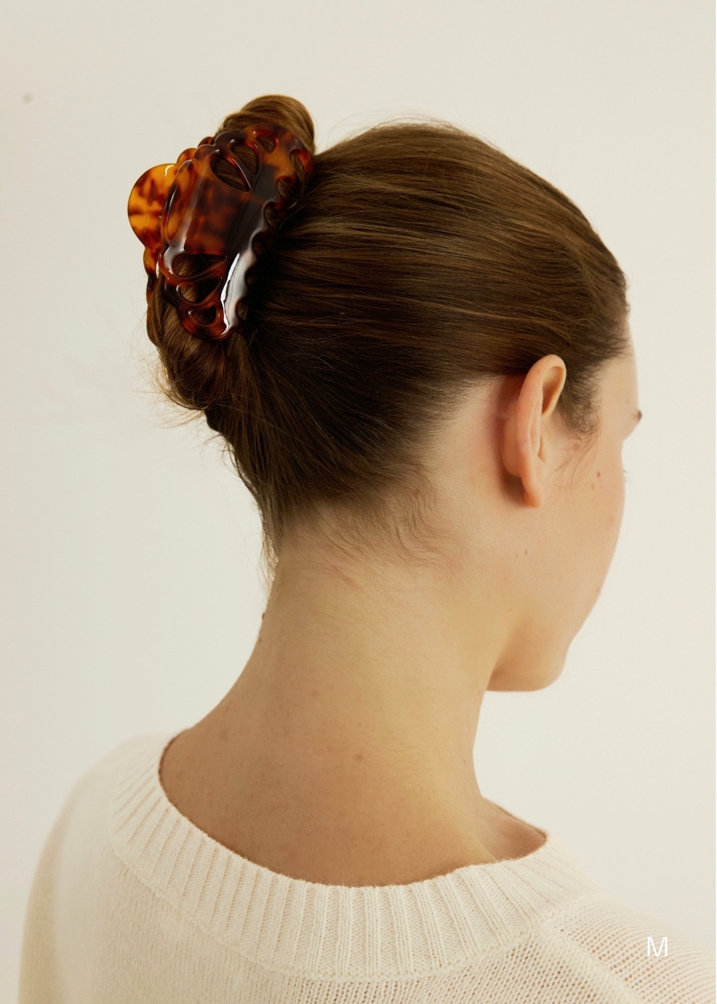 Woman with brown hair styled in an updo secured with a detailed tortoise-coloured claw clip