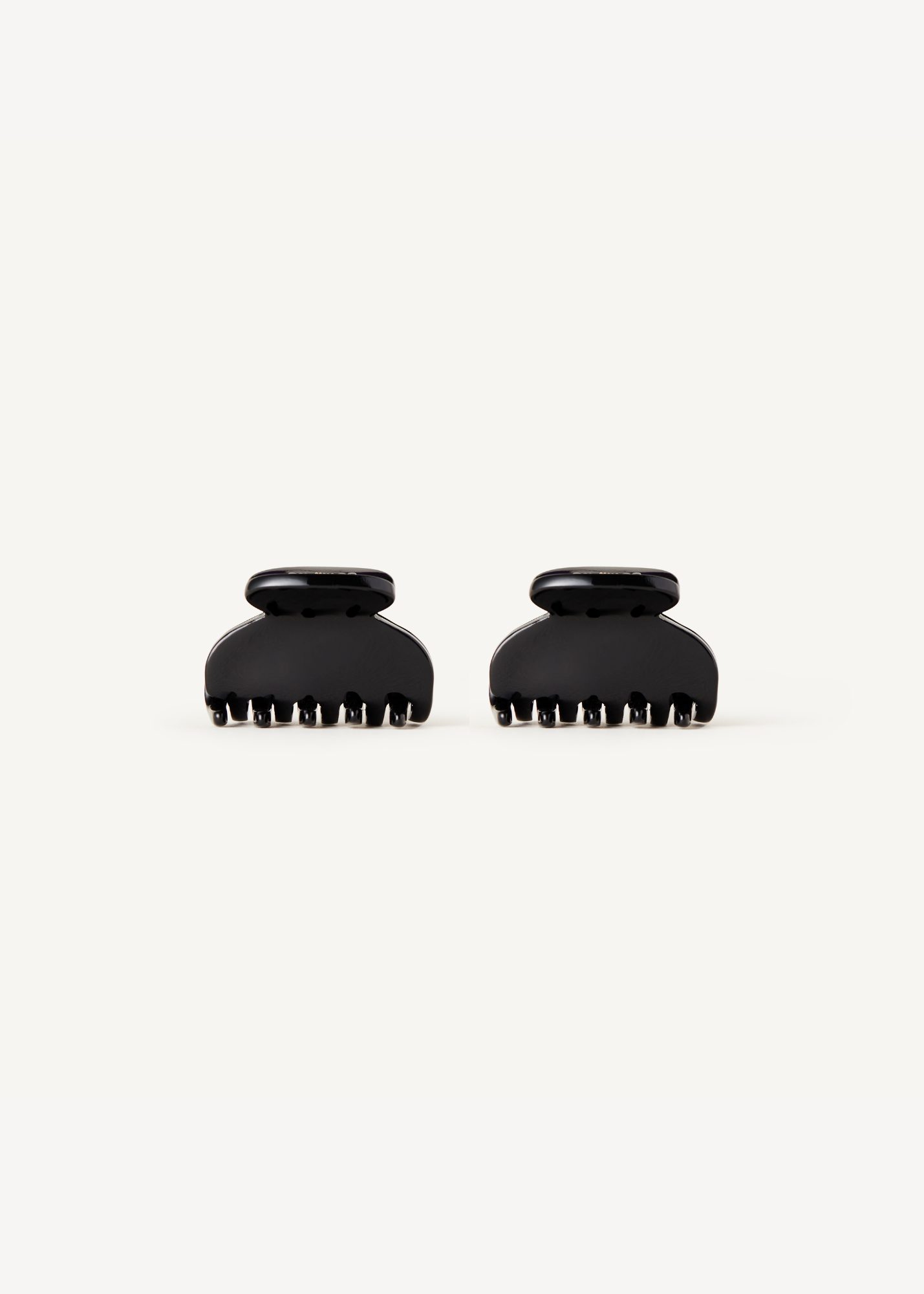 Two mini black clawclips on a white background