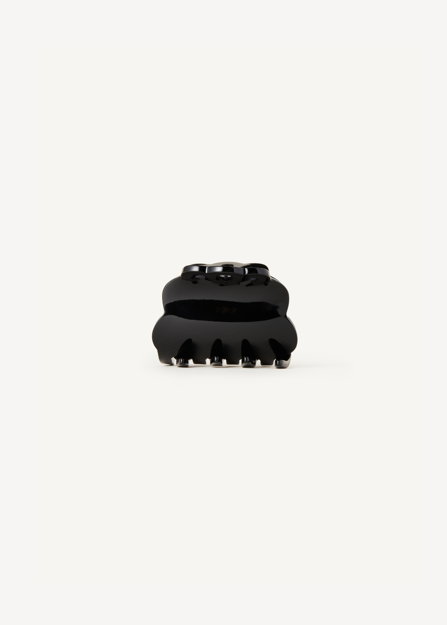 Black scalloped claw clip on a white background.