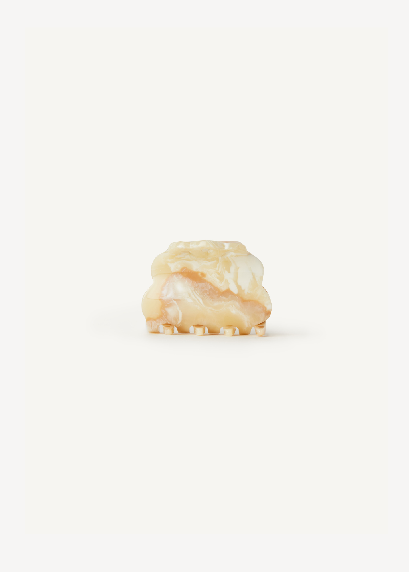 Scalloped, cream claw clip on a white background.
