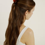 Woman with chestnut coloured hair in a half up, half down hairstyle secured with dark tortoise coloured mini hair claw clip.