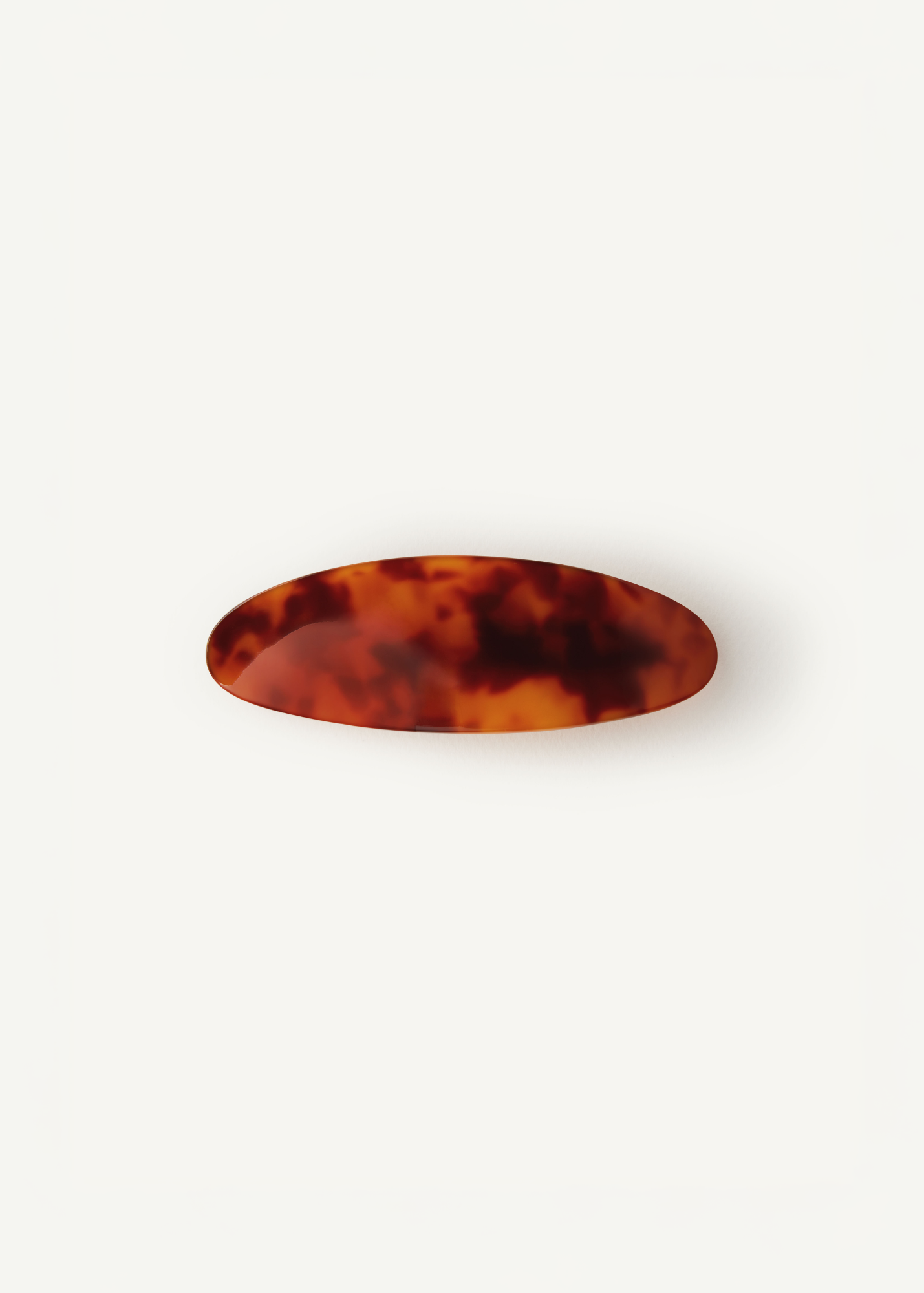 Oval shaped hair barrette in tortoiseshell on a white background.
