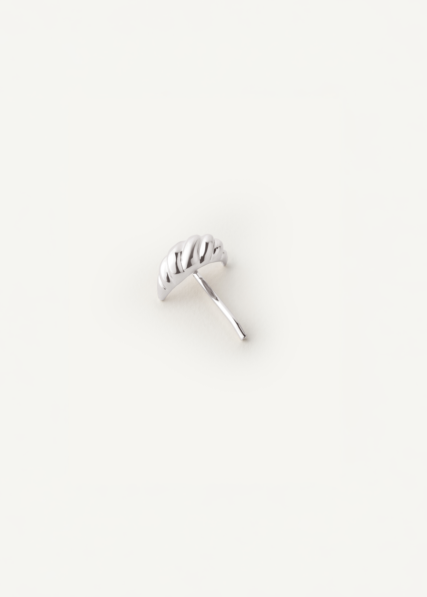 Silver croissant shaped hair accessory on a white background