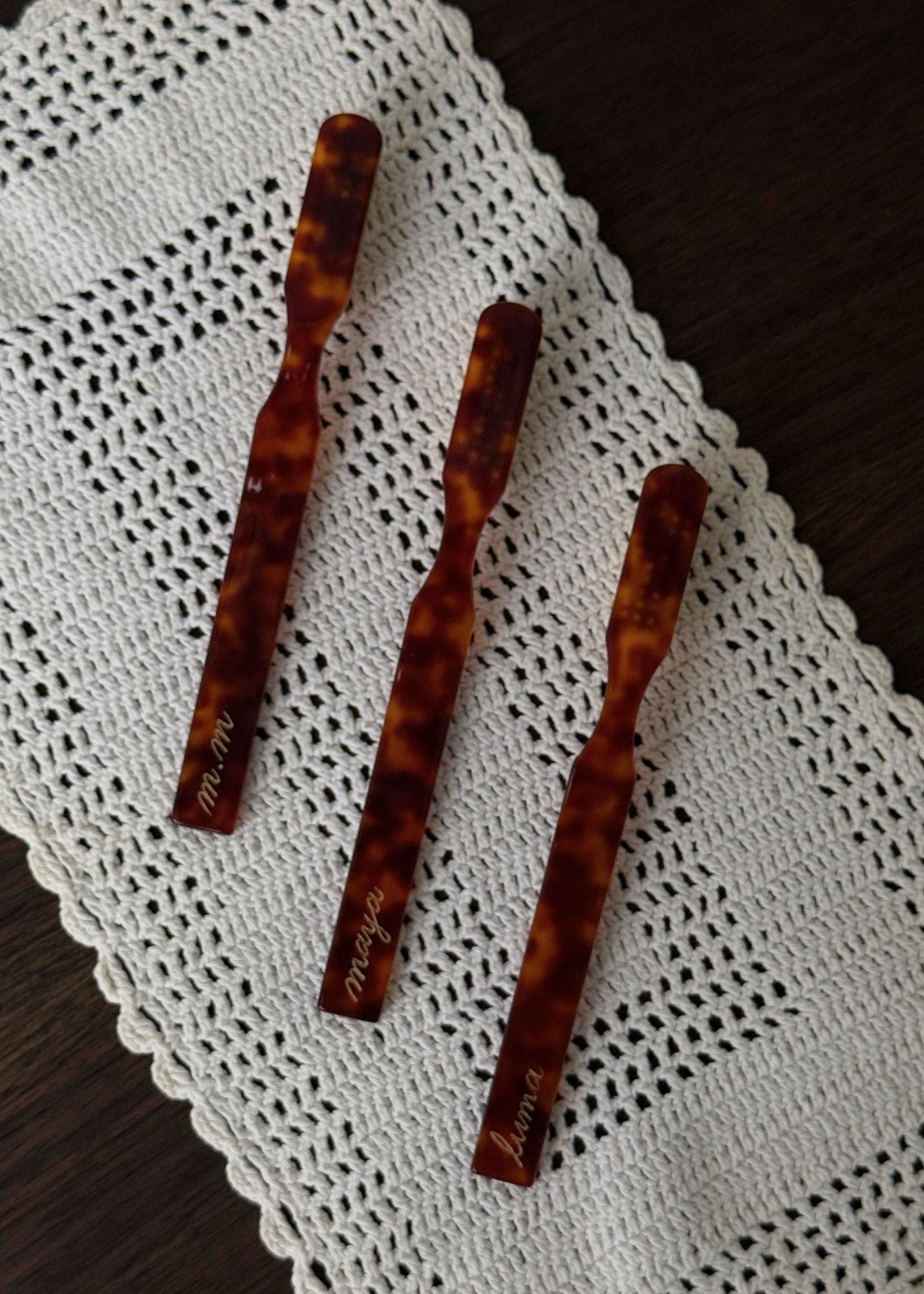 Three tortoise coloured fly-away brushes  on a white crochet doily