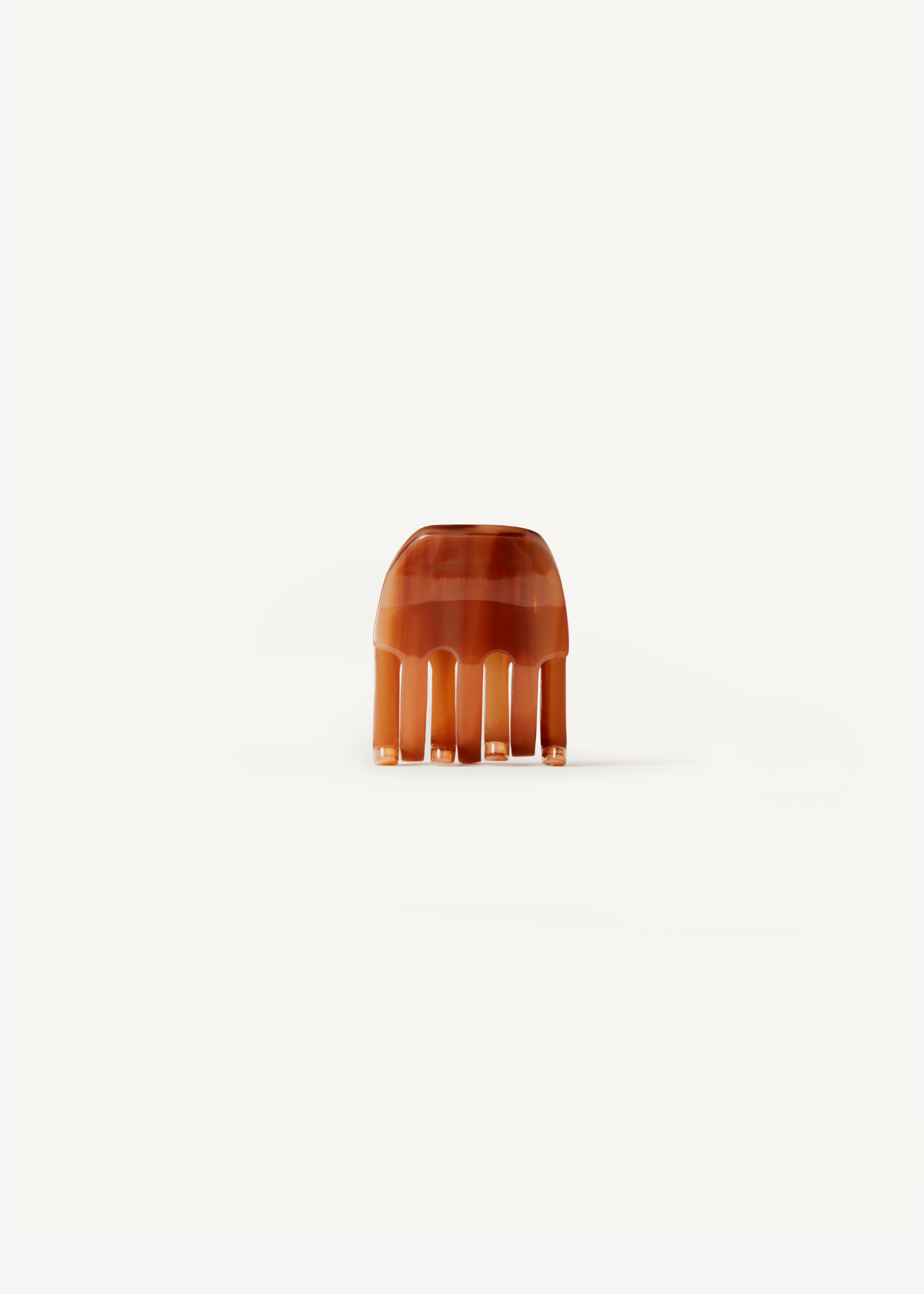 Small caramel coloured claw clip on a white background.