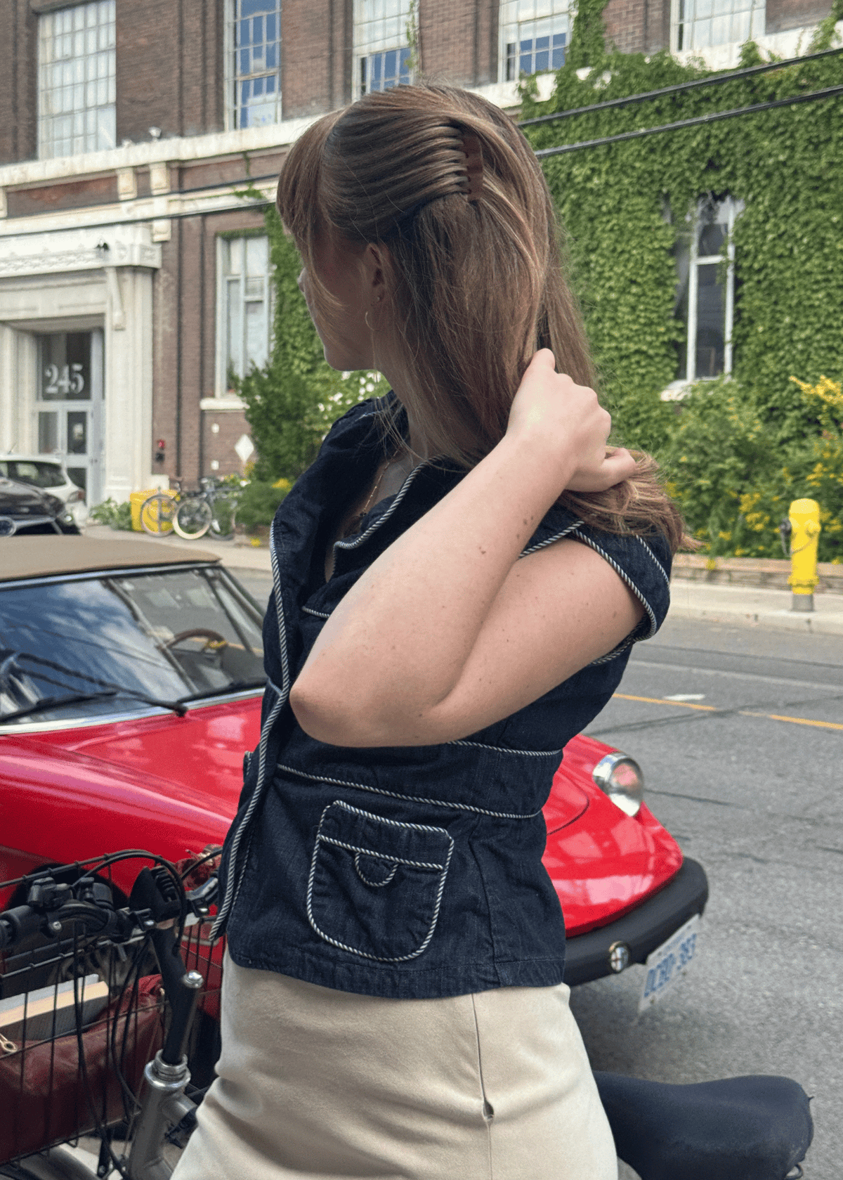 A woman stands beside a bicycle with her hair swept from her face using an amber brown hair comb.