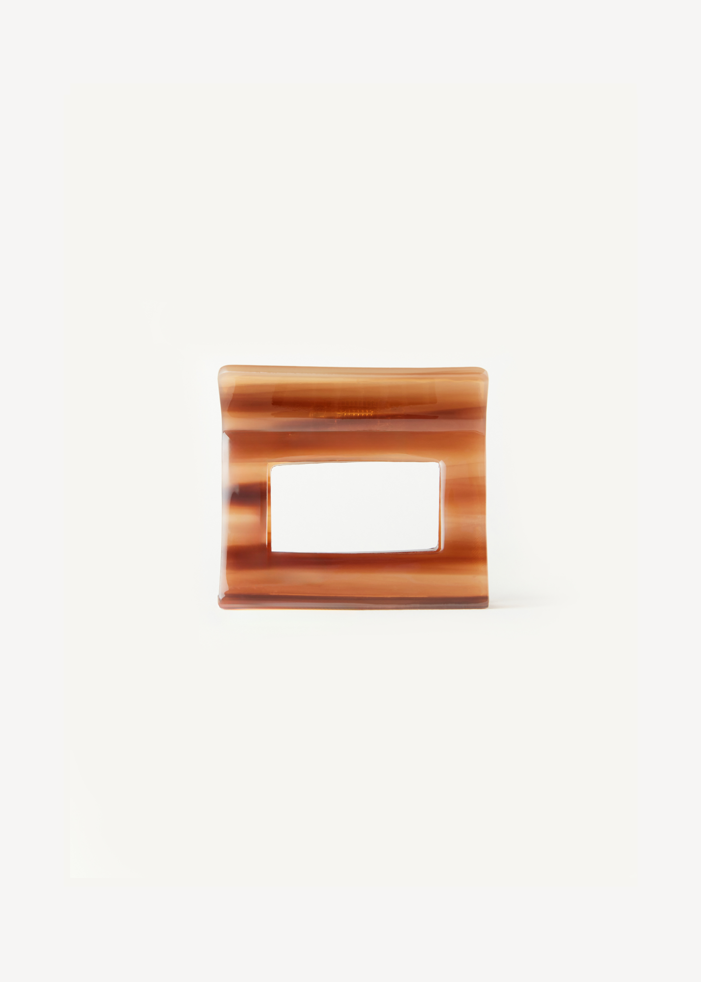 Caramel coloured hair clip on a white background.