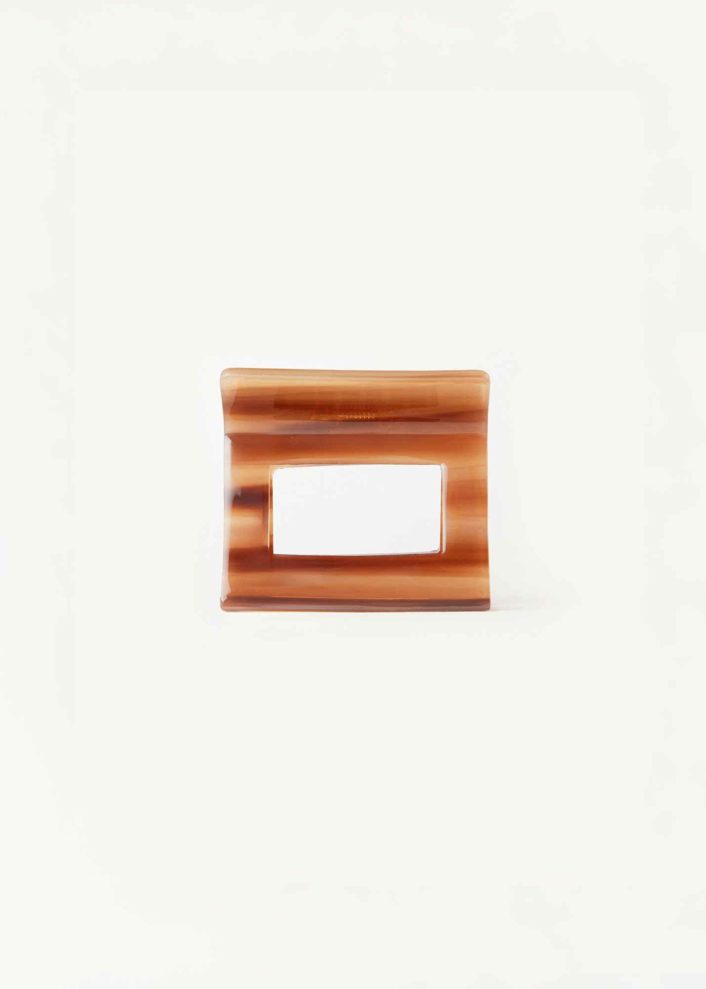 Caramel coloured hair clip on a white background.