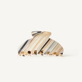 A striped pattern claw clip with beige, dark and light blue stripes on a white background