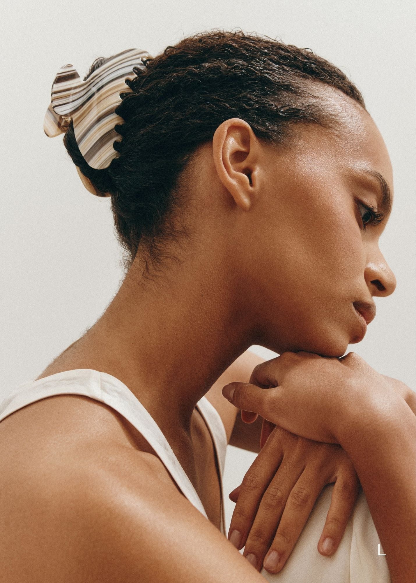 Woman with a striped claw clip looking away from the camera