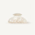 Pearl-coloured shell-shaped claw clip clip on a white background