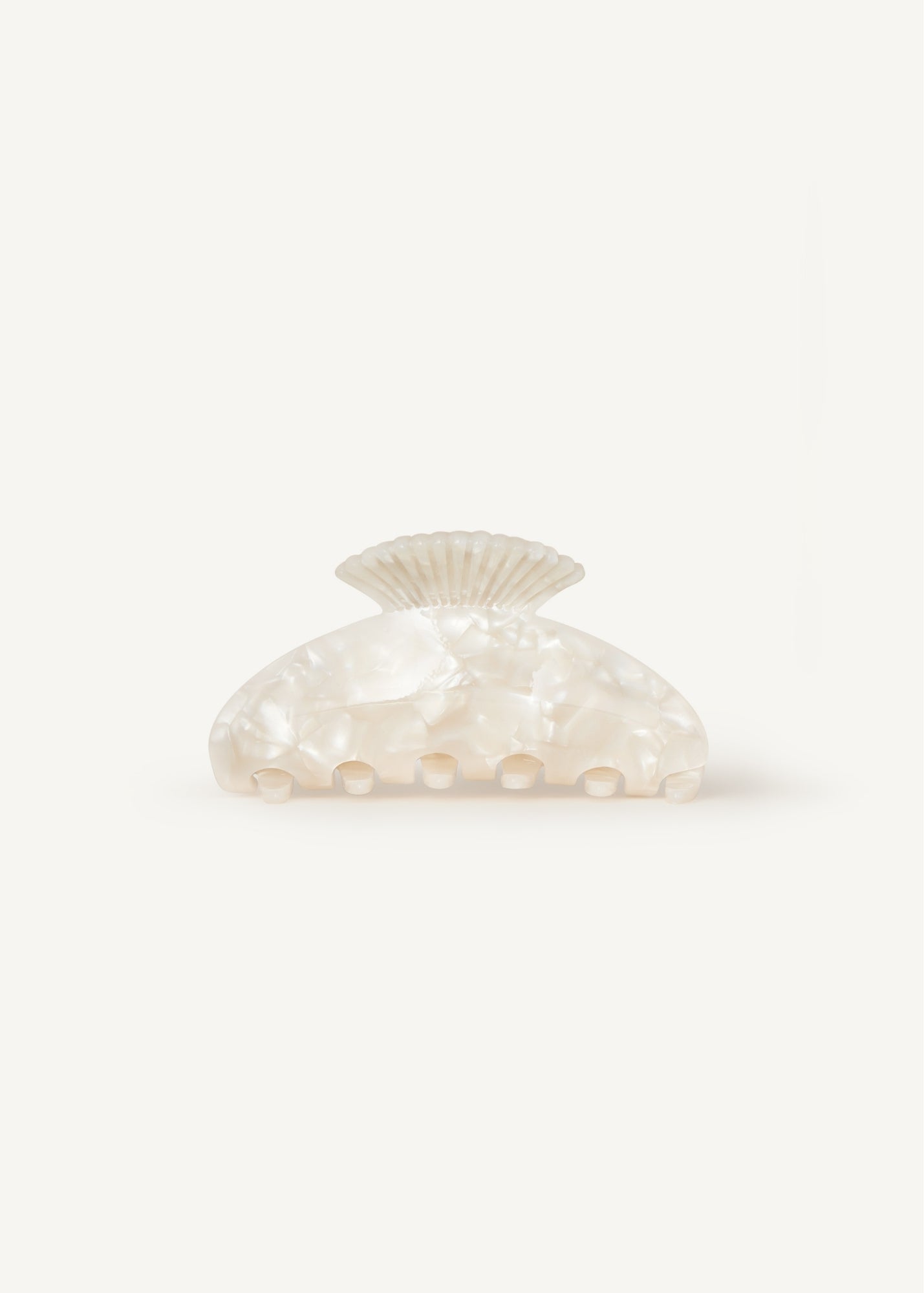 Pearl-coloured shell-shaped claw clip clip on a white background