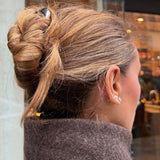 Woman with chestnut coloured hair styled in an updo secured with the French Pin in Silver and wearing a brown coat