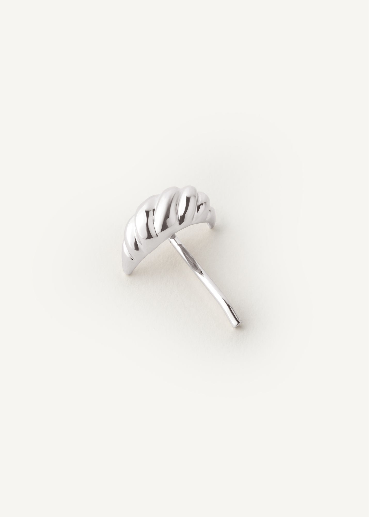 Silver croissant shaped hair accessory on a white background