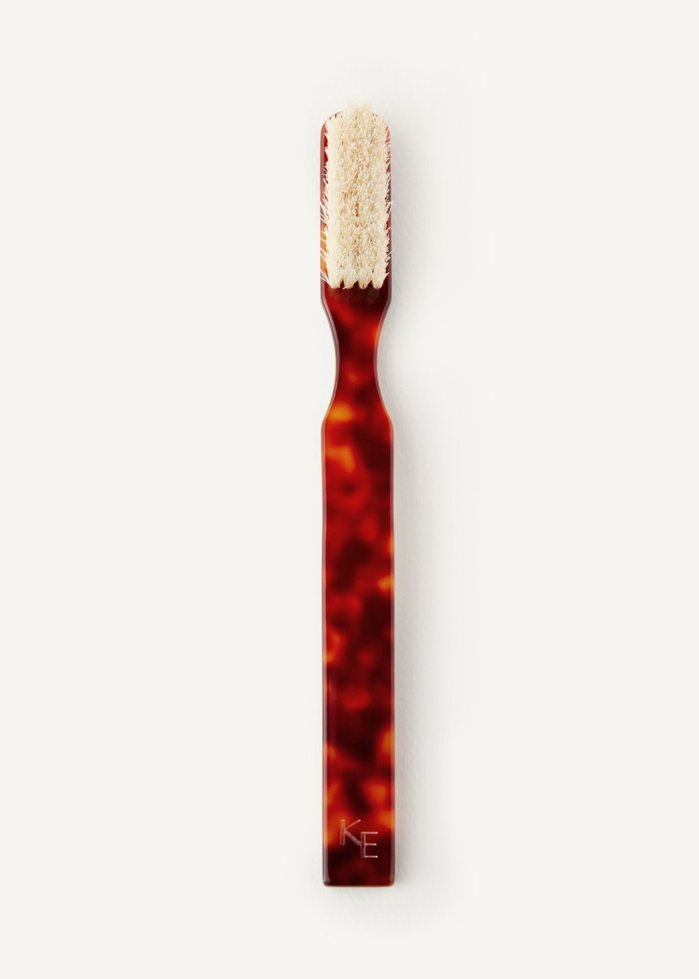 The Detail Brush in Tortoise, a small brush with beige coloured boar bristles on a white background
