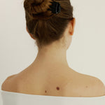Girl with brown hair in a bun secured with sculpt clip