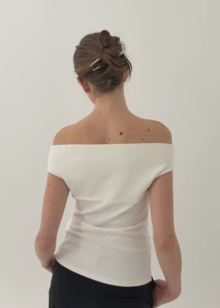 Woman with brunette hair styled in an u do secured with the French Pin in Silver wearing a white, off the shoulder top against a white background