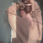 Video of woman styling her hair with the Banana Clip in Honey wearing a brown sweater